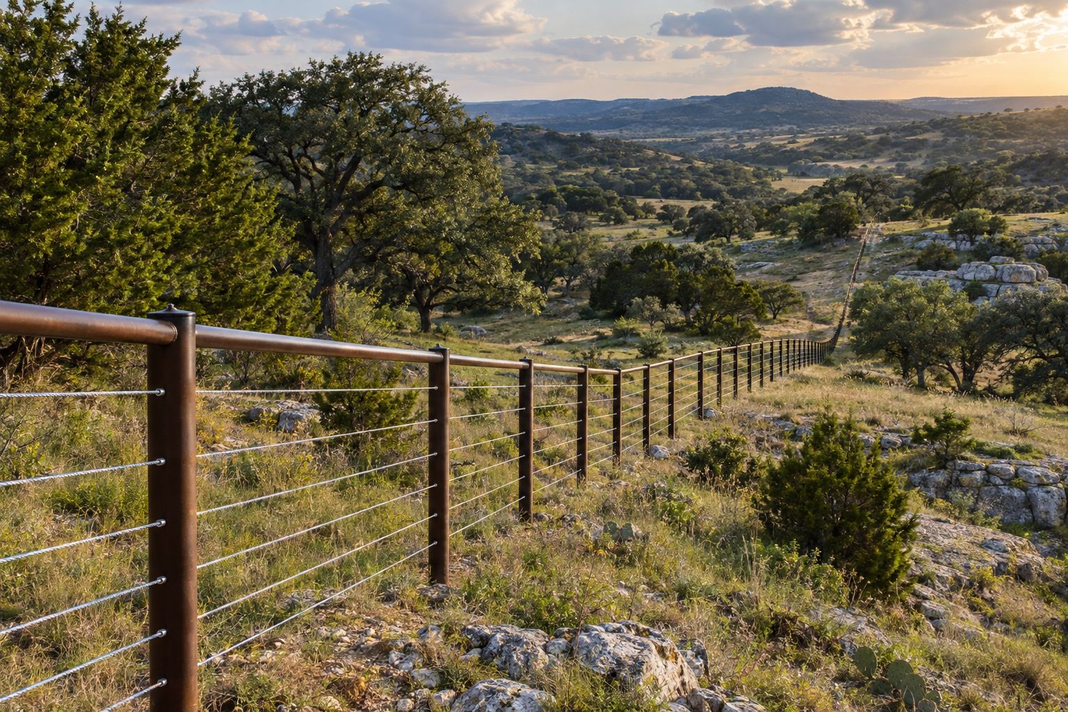 Pipe and cable ranch fence across pasture